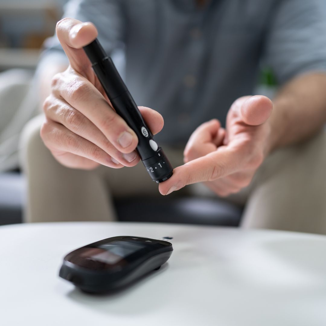Person using blood glucose meter to check sugar level for diabetes health monitoring